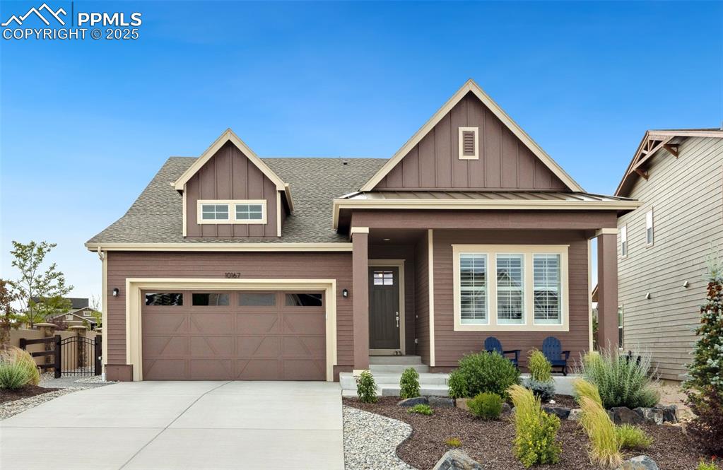 Image 11 of 49: Craftsman-style house featuring board and batten siding, driveway, a garage