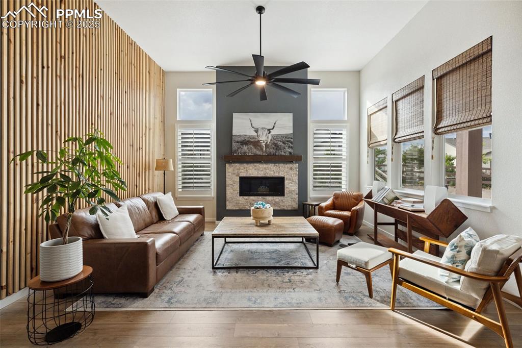 Image 13 of 49: Living area featuring a ceiling fan, hardwood / wood-style floors, wooden w