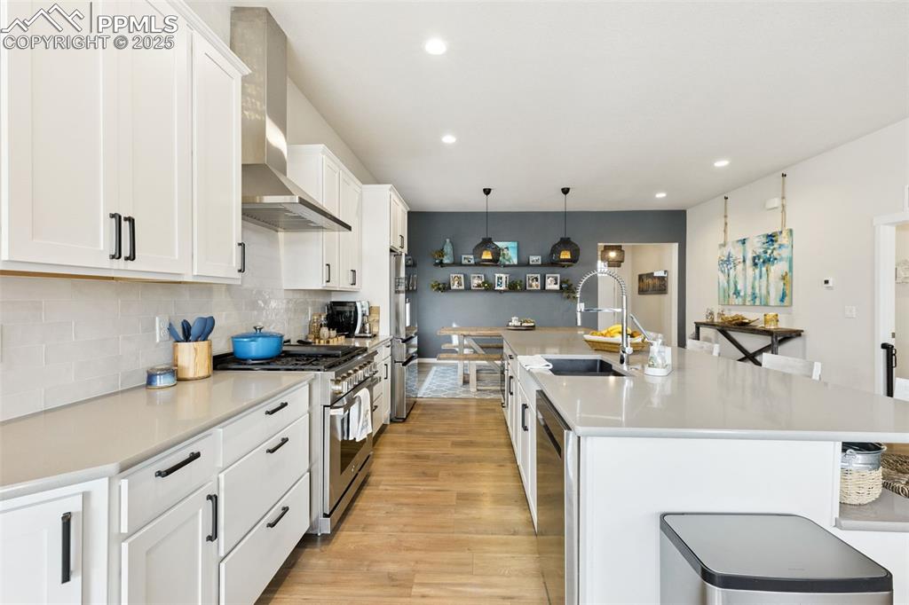 Image 18 of 49: Kitchen featuring appliances with stainless steel finishes, wall chimney ra