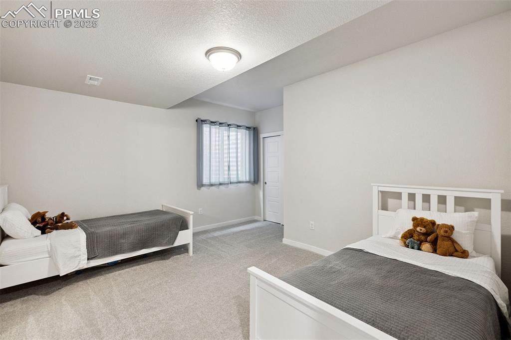 Image 29 of 49: Bedroom with light colored carpet and a textured ceiling