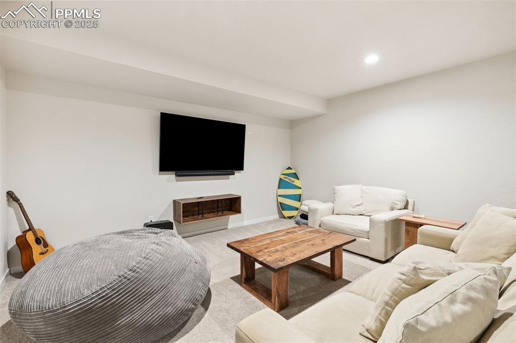 Image 37 of 49: Living area with light colored carpet and recessed lighting