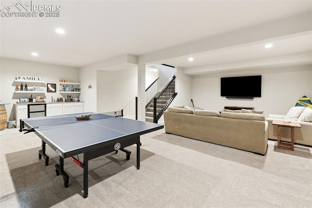 Image 40 of 49: Playroom featuring bar, light carpet, and recessed lighting