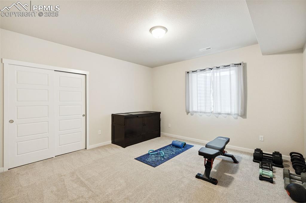 Image 41 of 49: Workout room with carpet flooring and baseboards