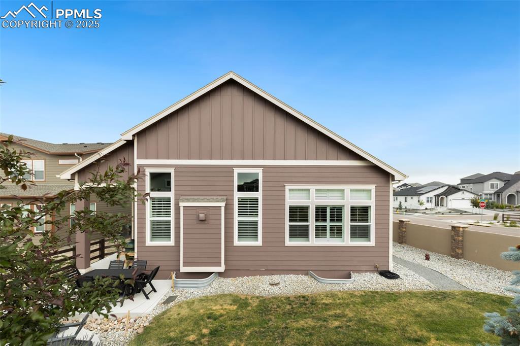 Image 44 of 49: View of front of home with board and batten siding and a patio area