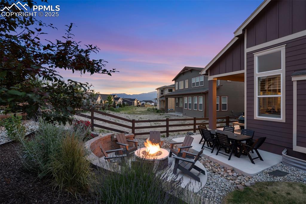 Image 48 of 49: Yard at dusk with an outdoor fire pit and a patio area
