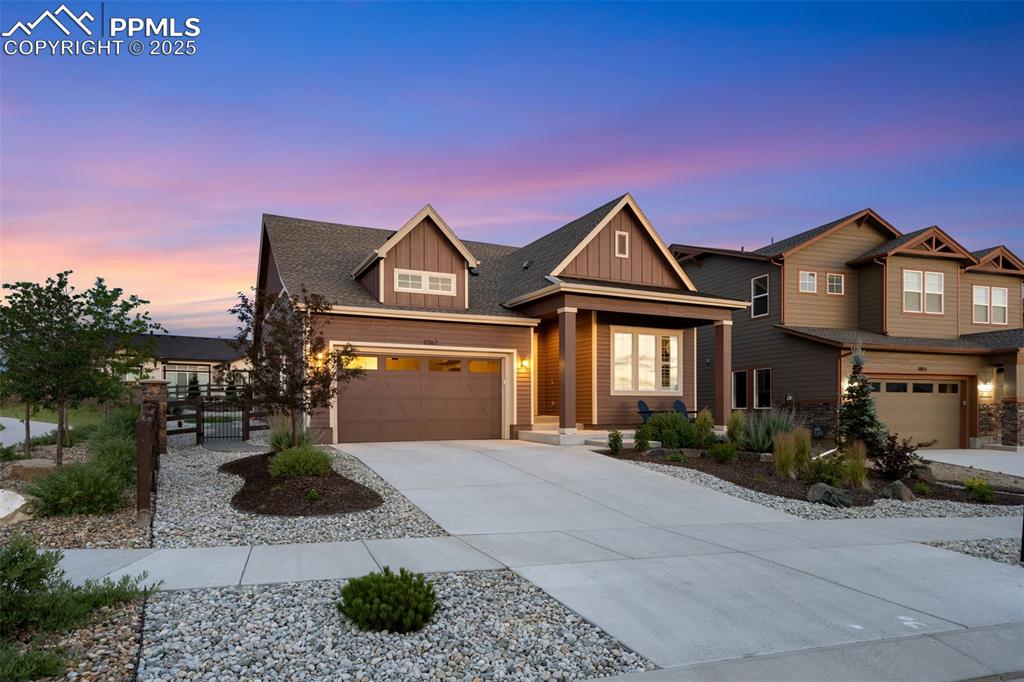 Image 7 of 49: Craftsman inspired home with board and batten siding, concrete driveway, a