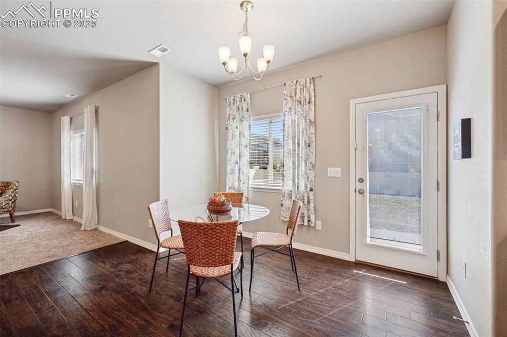 Image 13 of 39: Dining area featuring dark wood-type flooring and a chandelier