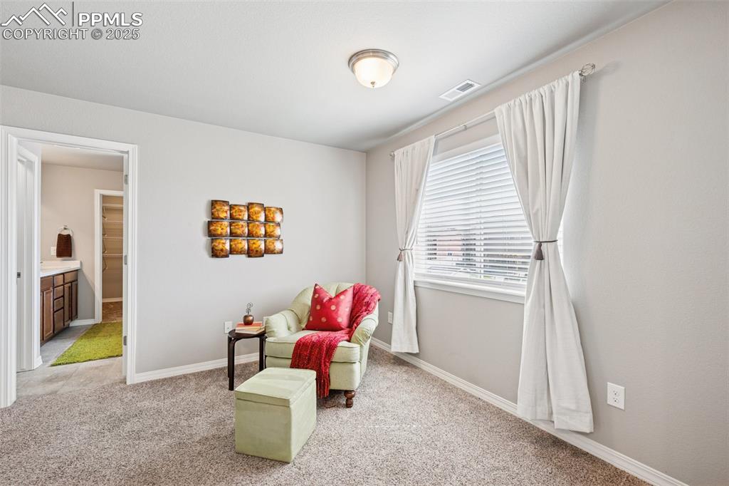 Image 16 of 39: Sitting area with light colored carpet and baseboards