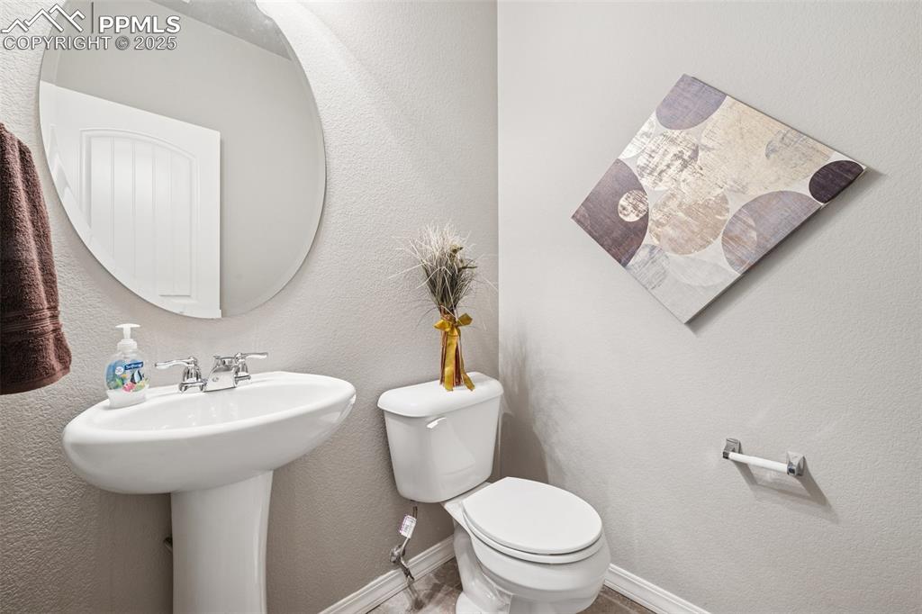 Image 19 of 39: main level Half bathroom with a textured wall