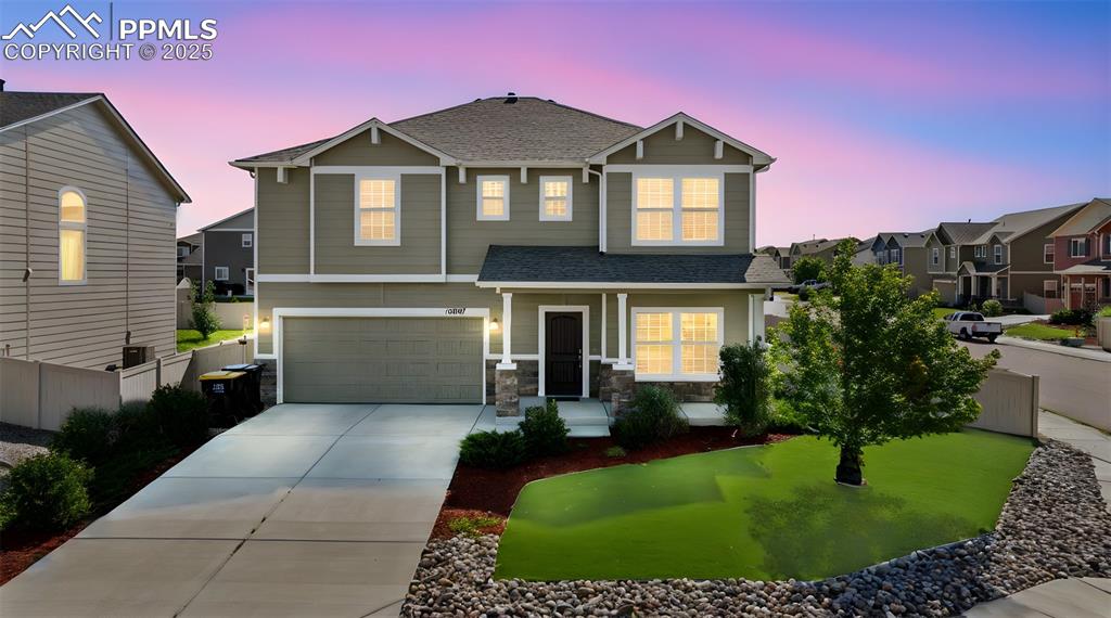 Image 2 of 39: Craftsman-style house with a shingled roof, covered porch, driveway, a gara