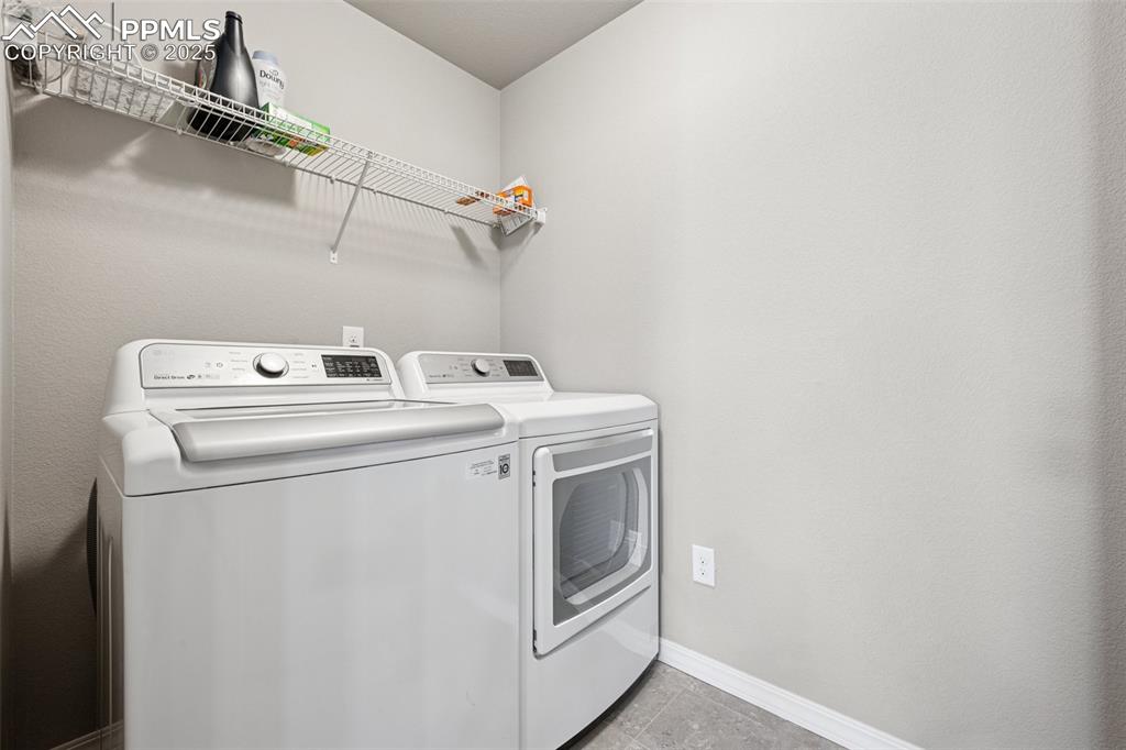 Image 20 of 39: upper level Laundry area with separate washer and dryer and light tile patt