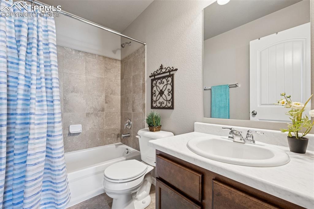Image 21 of 39: Full bathroom featuring shower / bathtub combination with curtain, a textur