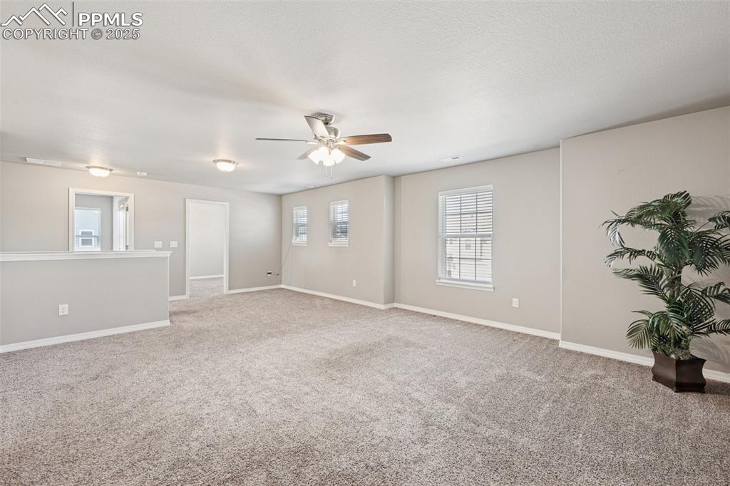 Image 23 of 39: Spare room featuring light carpet and a ceiling fan
