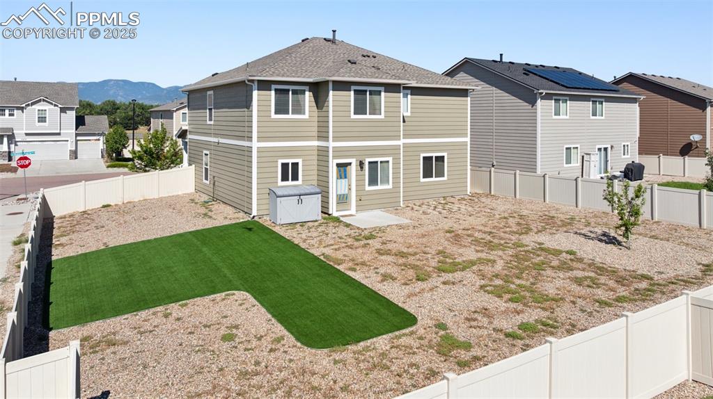 Image 31 of 39: Back of house with a residential view, a fenced backyard, and a mountain vi