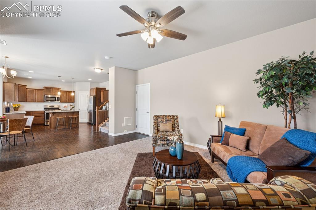 Image 5 of 39: Living area featuring dark carpet, stairs, a ceiling fan, recessed lighting