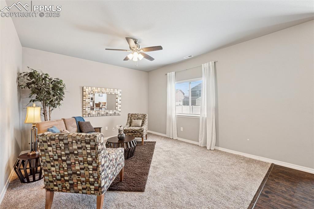 Image 6 of 39: Sitting room with carpet floors and ceiling fan