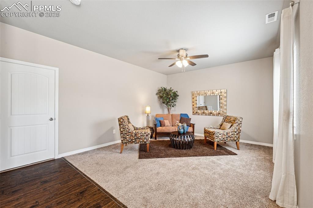 Image 7 of 39: Sitting room featuring wood finished floors, a ceiling fan, and carpet floo