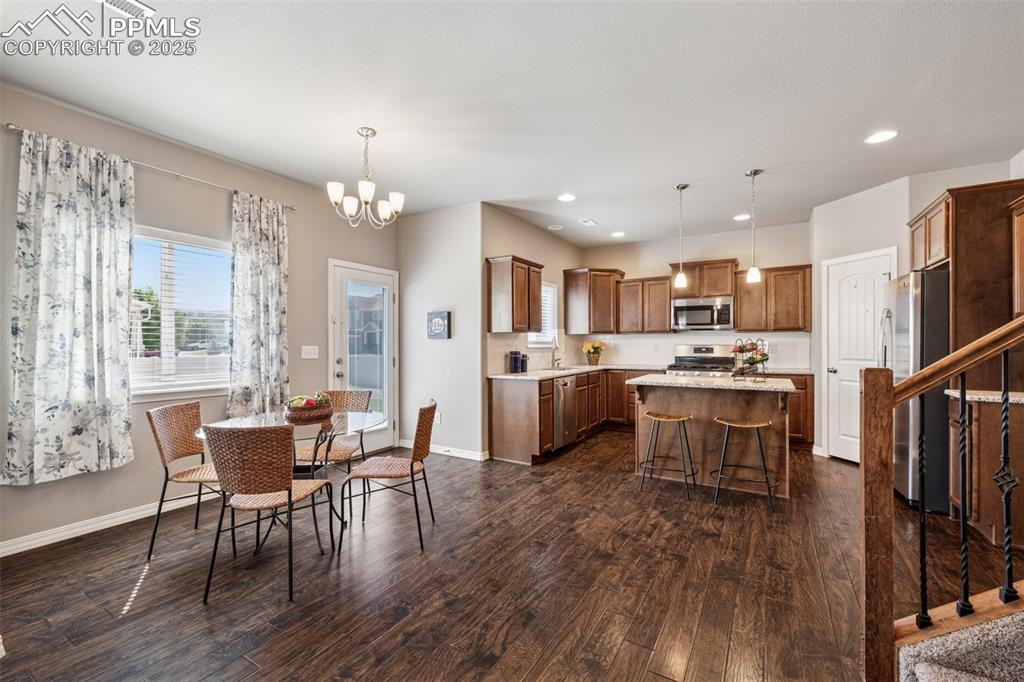 Image 9 of 39: Dining area with a chandelier, recessed lighting, dark wood-style flooring,