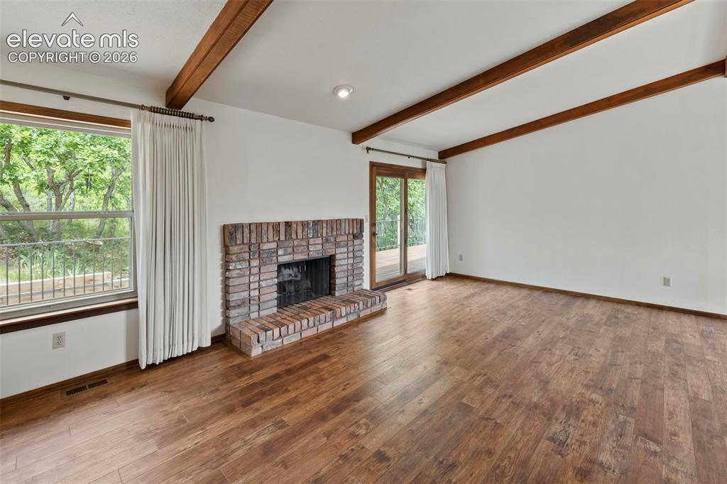 Image 10 of 30: Features a fireplace, lots of natural light and door that leads to back dec