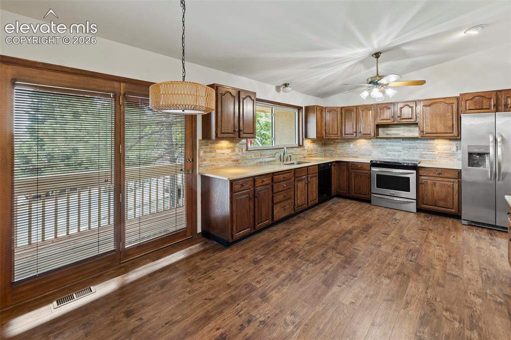 Image 11 of 30: Abundance of cabinets along with a planning desk and a door to a covered fr