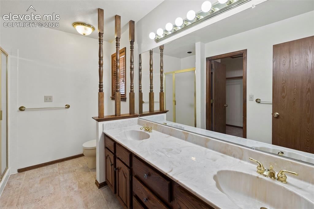 Image 13 of 30: Primary bathroom with double vanities, oversized shower and a walk-in close