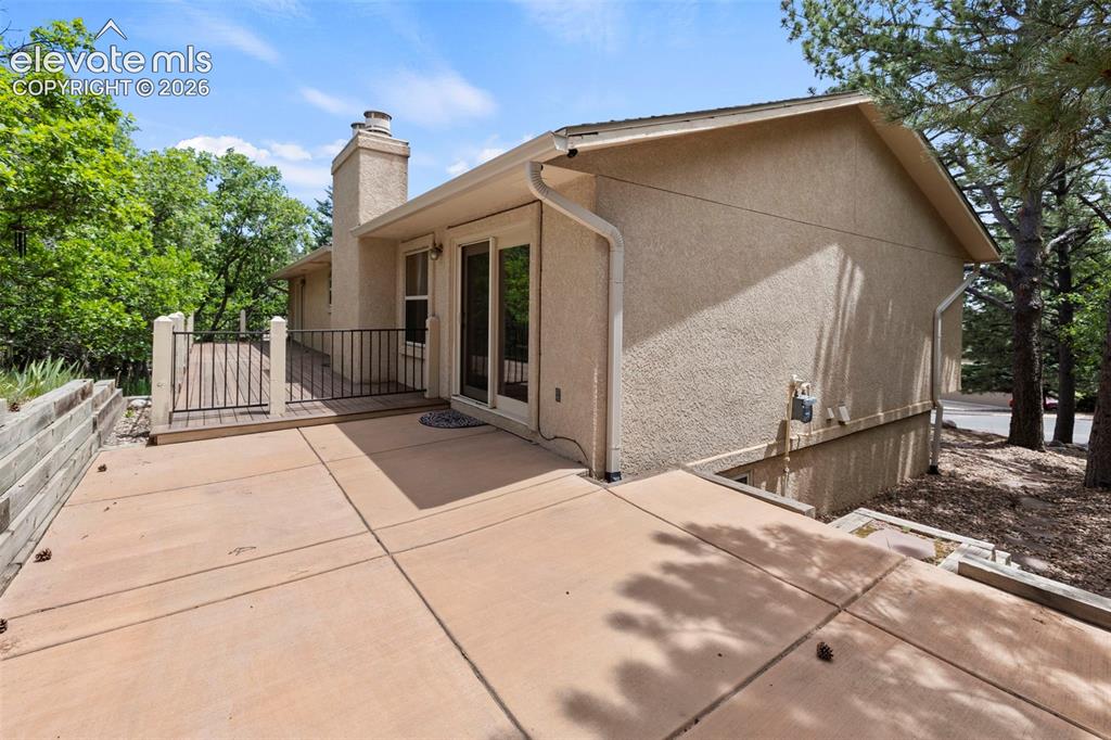 Image 25 of 30: Patio with stairs to front yard along side of the house