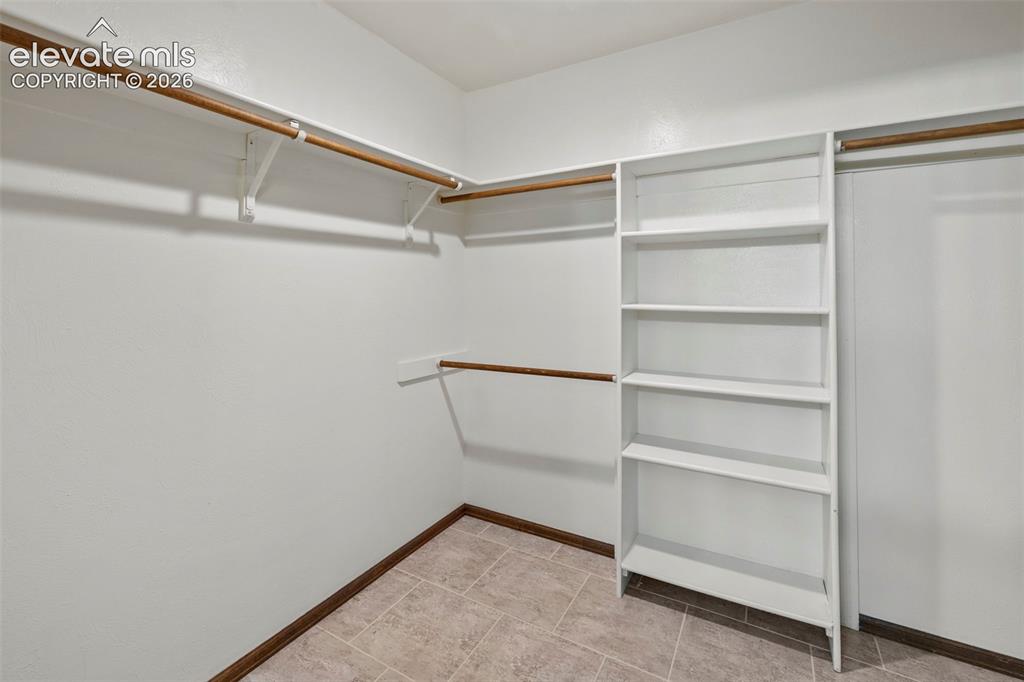 Image 30 of 30: Primary walk-in closet with shelving