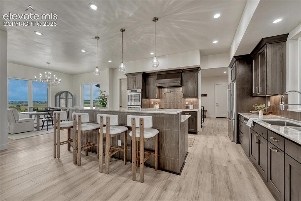 Image 13 of 49: Beautifully appointed kitchen with sweeping island, quartzite countertops..