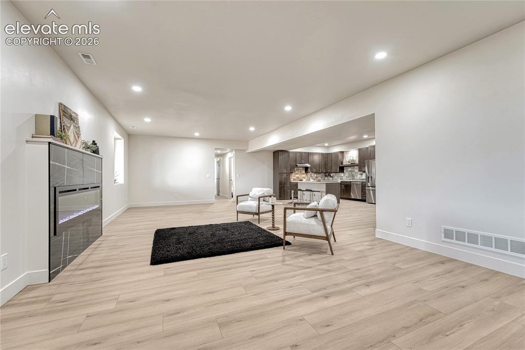 Image 36 of 49: Lower level great room with electric fireplace....
