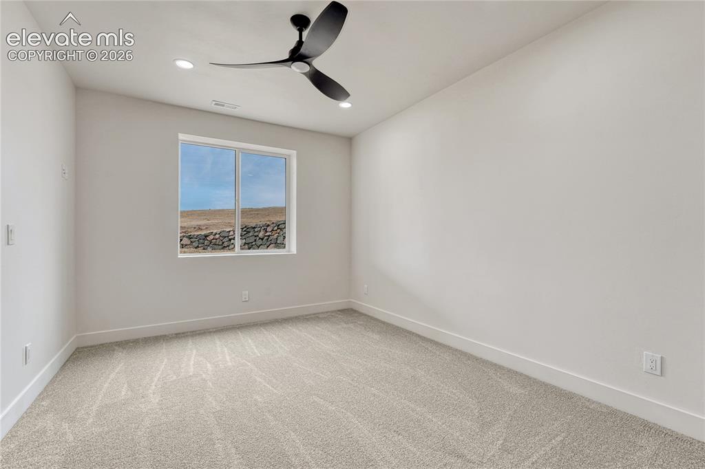 Image 44 of 49: First of two lower level bedrooms.