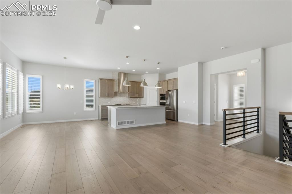 Image 11 of 48: Open-concept living room with luxury vinyl plank flooring, open staircase r