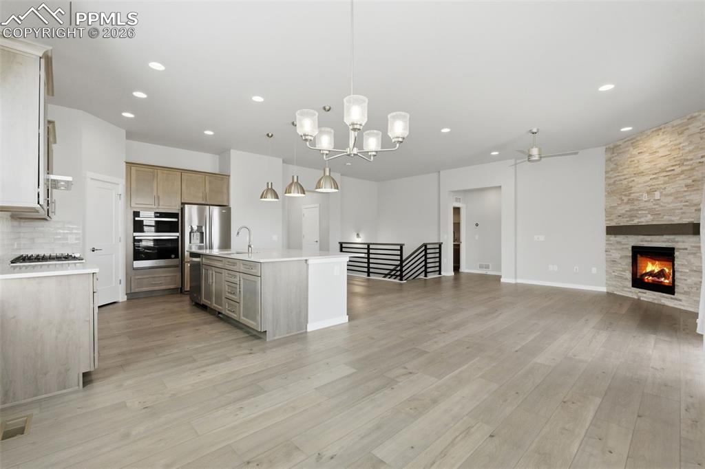 Image 14 of 48: Kitchen featuring chandelier lighting, large island with pendant lights, an