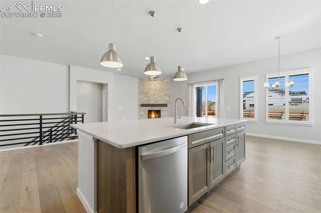 Image 16 of 48: Stunning kitchen with pendant lighting over island, quartz countertops, and