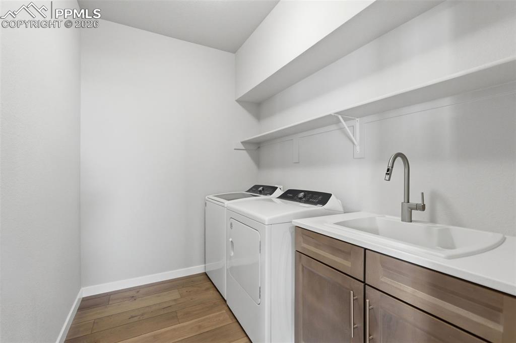 Image 19 of 48: Spacious laundry room with upper cabinet storage, utility sink, and ample c