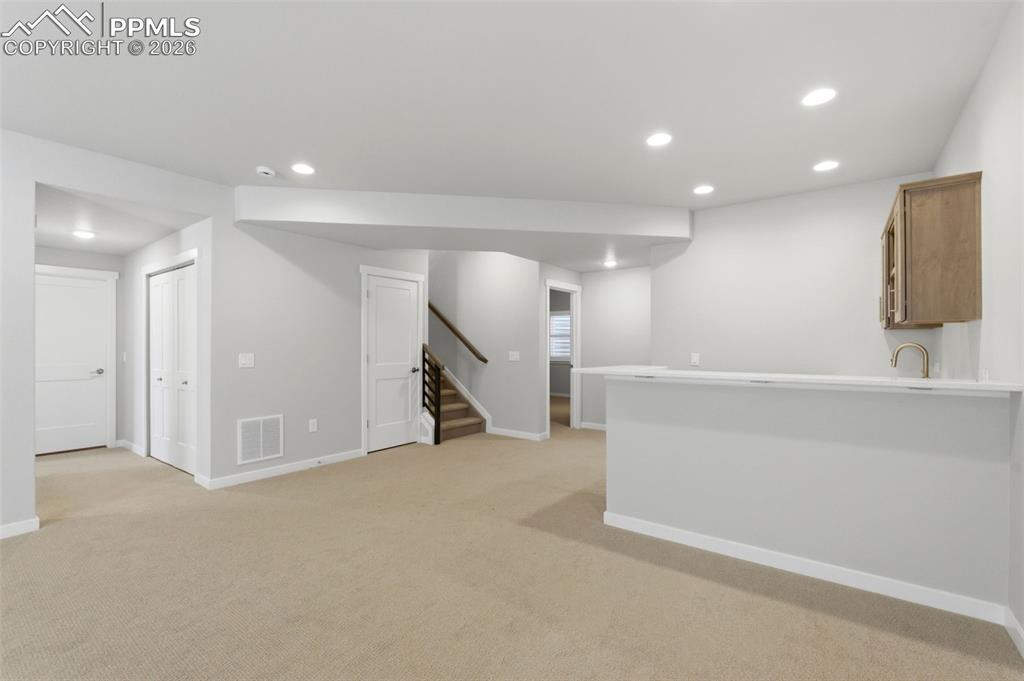 Image 28 of 48: Finished basement area with recessed lighting, neutral carpet, and open lay