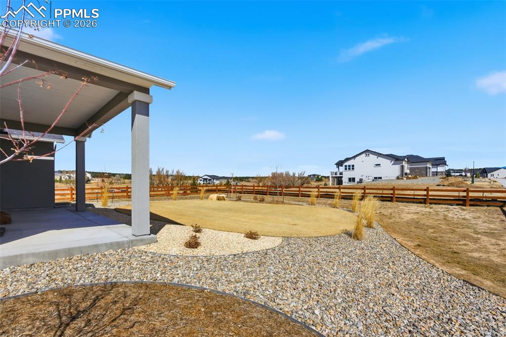 Image 38 of 48: Beautiful backyard with spacious patio, mature landscaping, and mountain vi