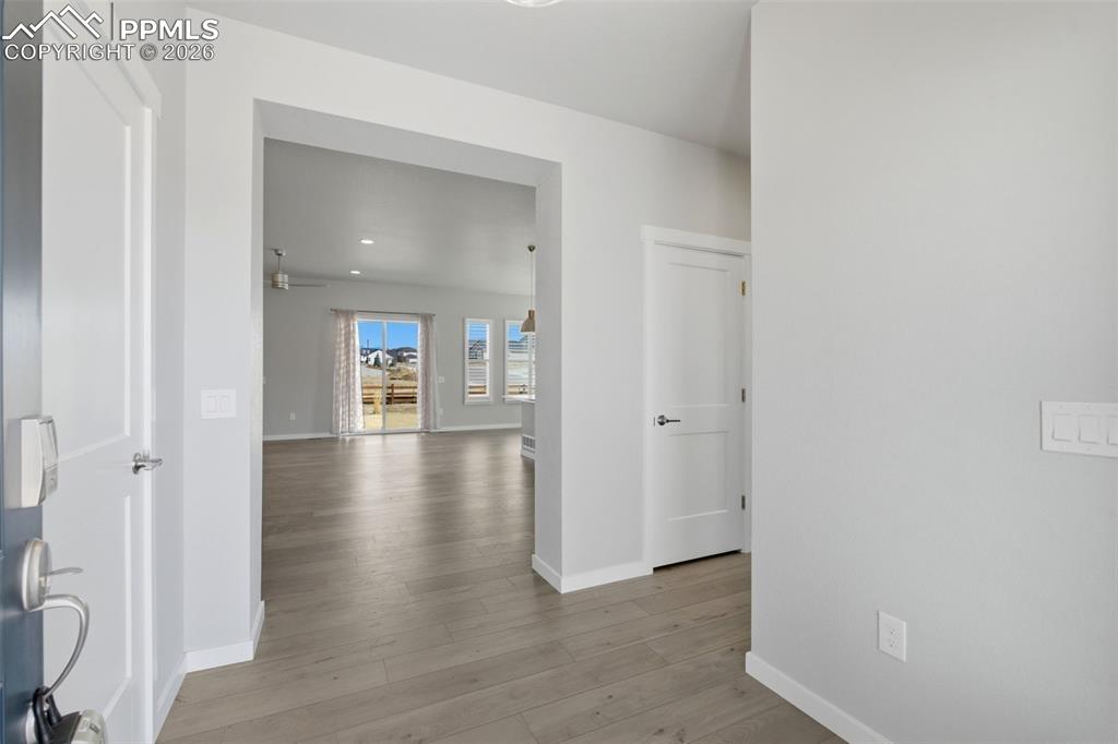 Image 7 of 48: Open hallway with luxury vinyl plank flooring leading to main living areas
