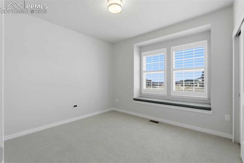 Image 8 of 48: Versatile room with large windows, neutral carpet, and ample natural light 