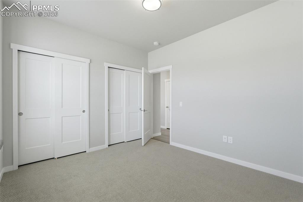 Image 9 of 48: Spacious bedroom with neutral carpet, large closet with double doors, and p
