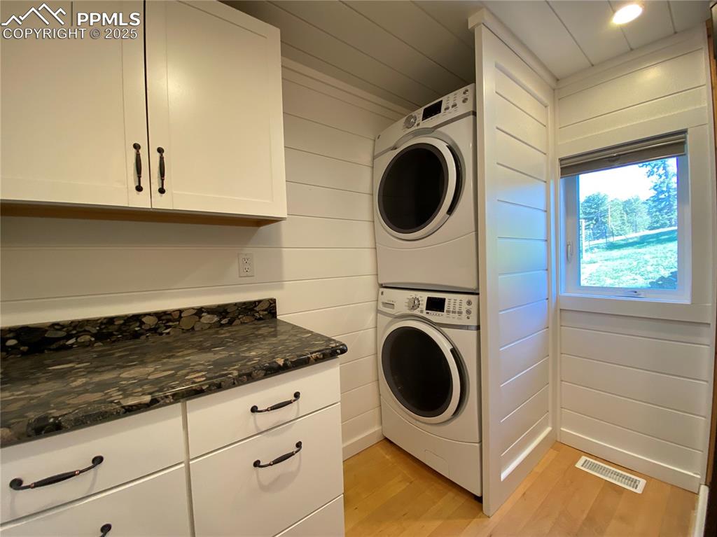 Image 17 of 36: The main-level laundry space has a folding table