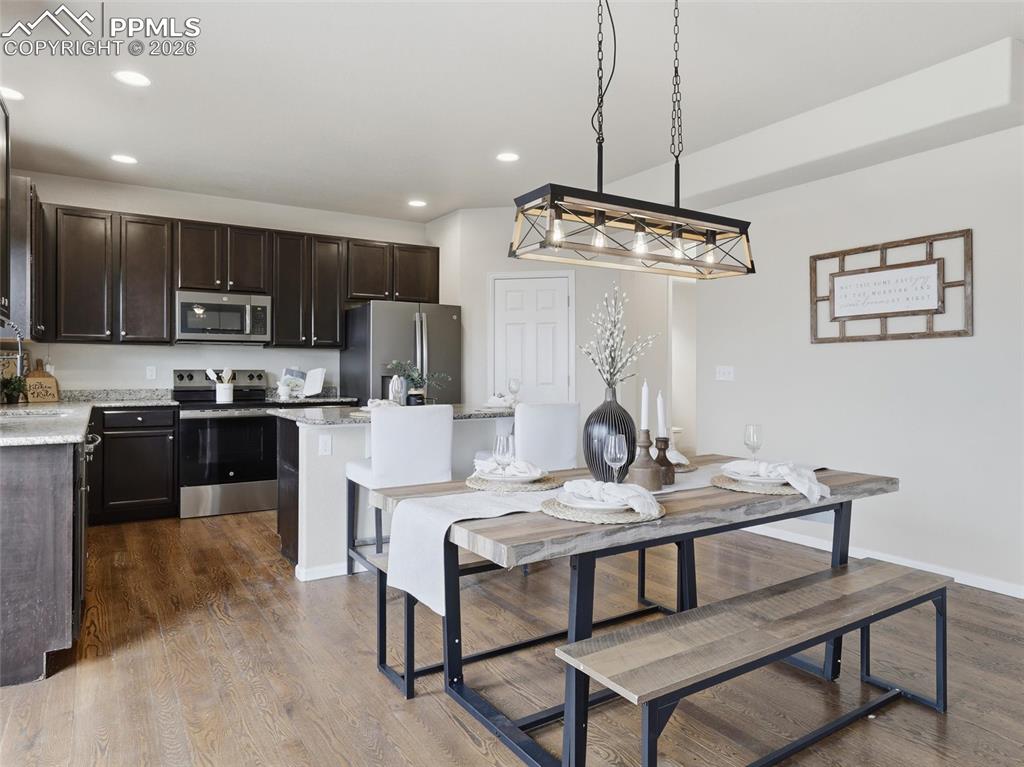 Image 19 of 45: Dining area with dark wood-style flooring and recessed lighting