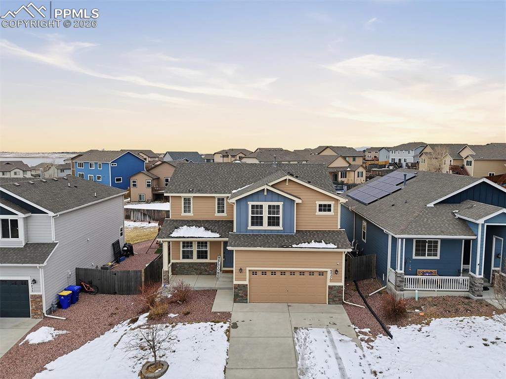 Image 2 of 45: View of front facade with stone siding, an attached garage, concrete drivew