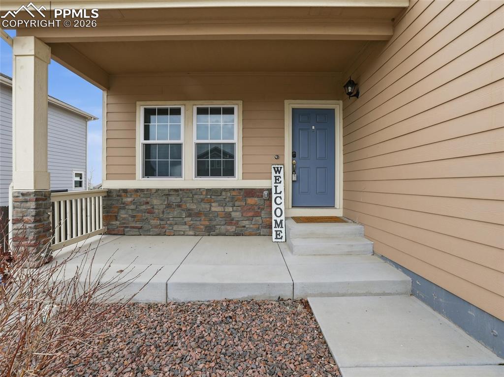 Image 3 of 45: Property entrance with stone siding and covered porch