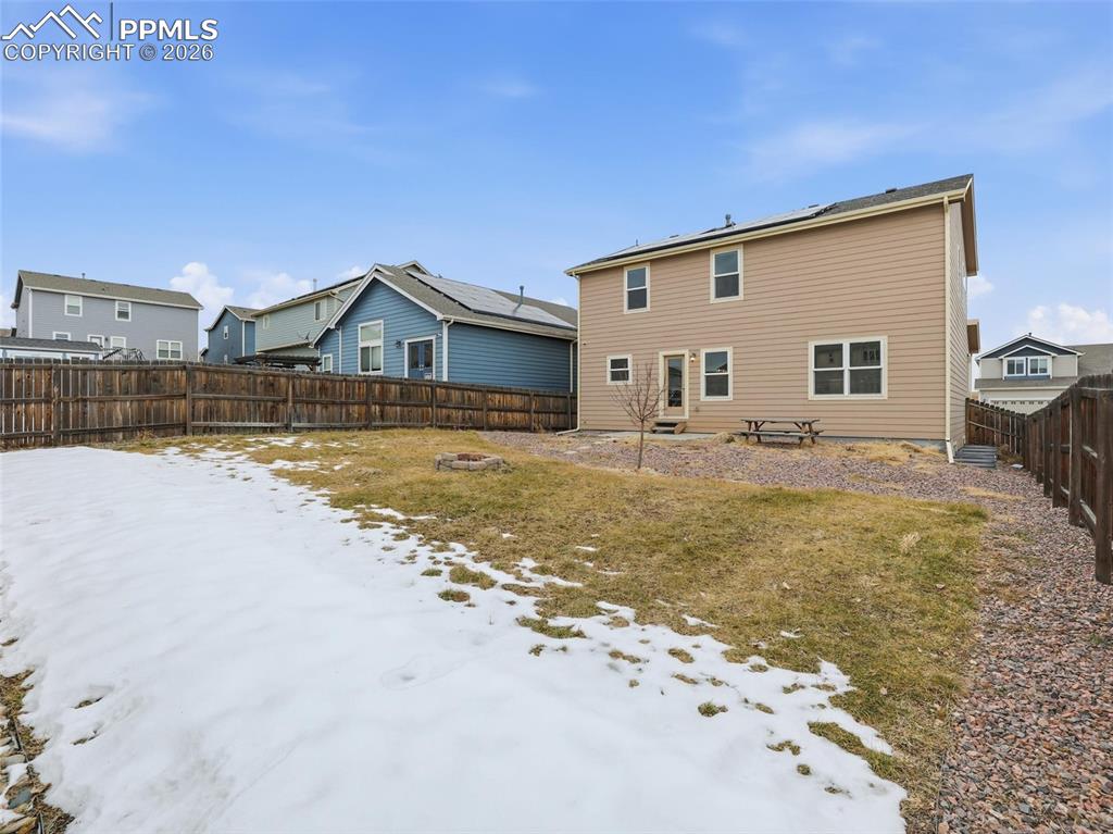 Image 40 of 45: Snow covered house with a fenced backyard and a residential view