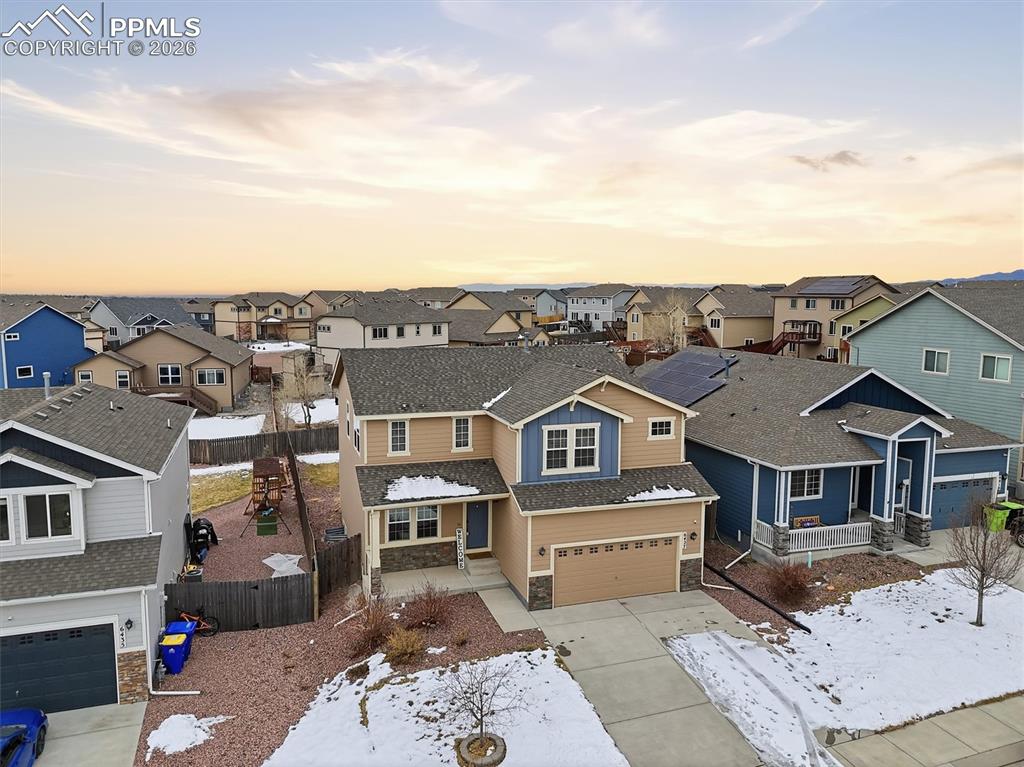 Image 42 of 45: View of front of home featuring stone siding, driveway, a garage, a residen