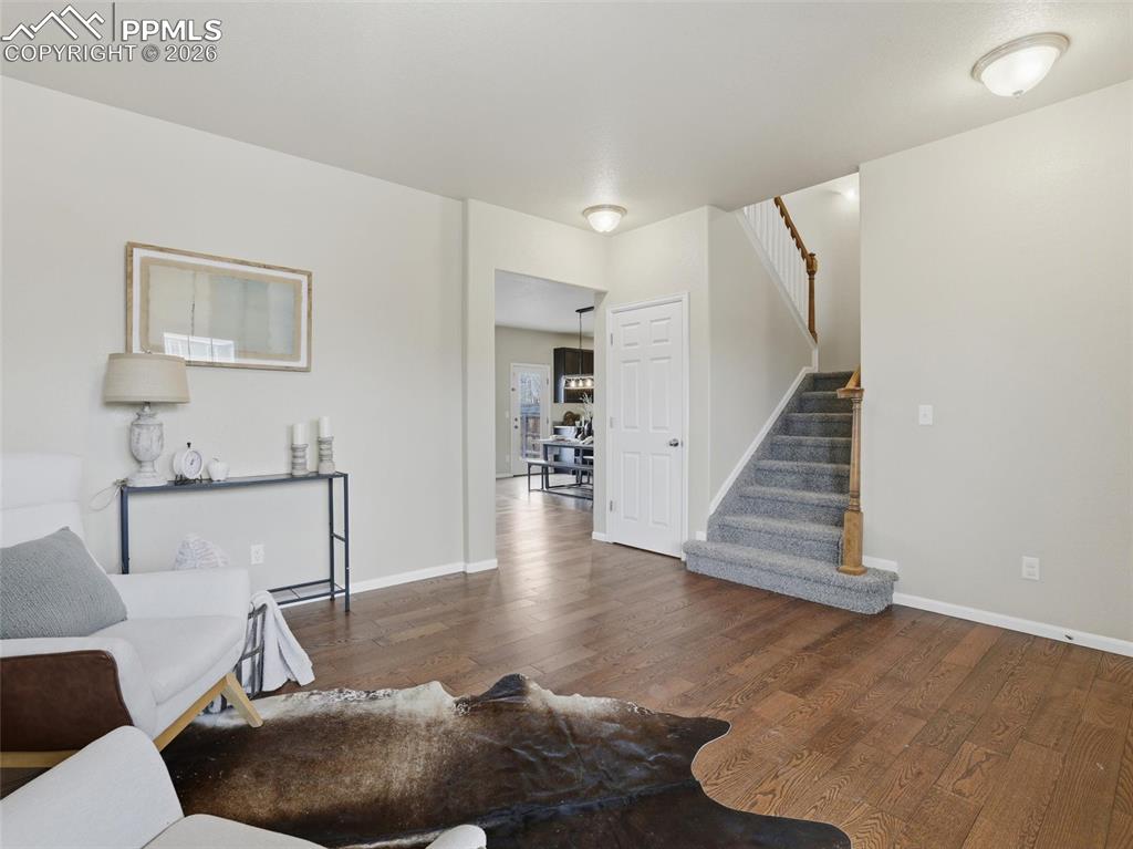 Image 6 of 45: Living room with stairway and wood finished floors