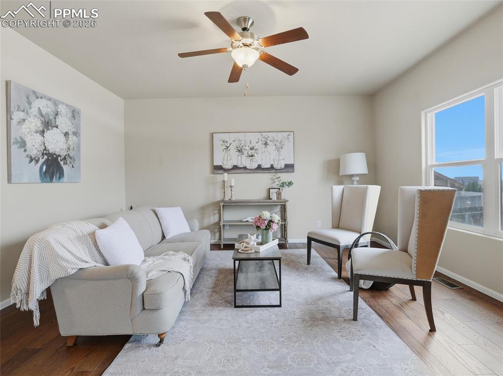 Image 8 of 45: Living room featuring wood finished floors and ceiling fan