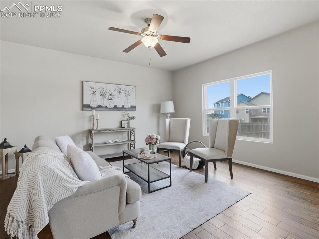 Image 9 of 45: Living area featuring light wood finished floors and ceiling fan