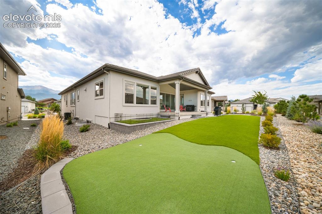 Image 38 of 45: Turf with putting green and small dog run.