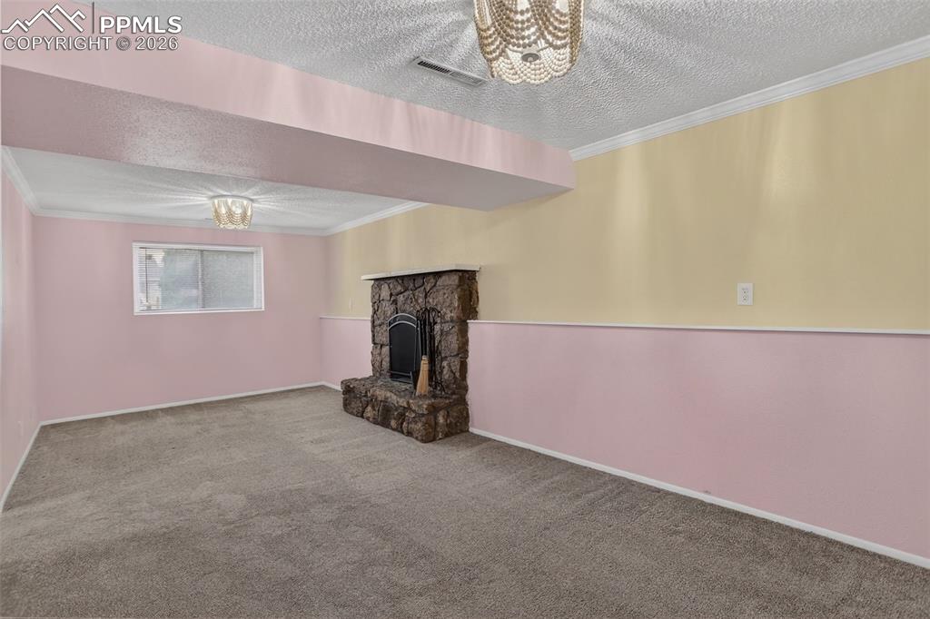 Image 34 of 44: Lower level family room with walk-out and wood-burning fireplace. 